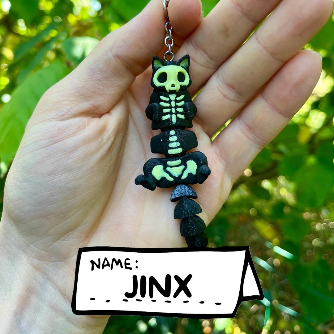 Glow-in-the-dark articulated skeleton cat keychain