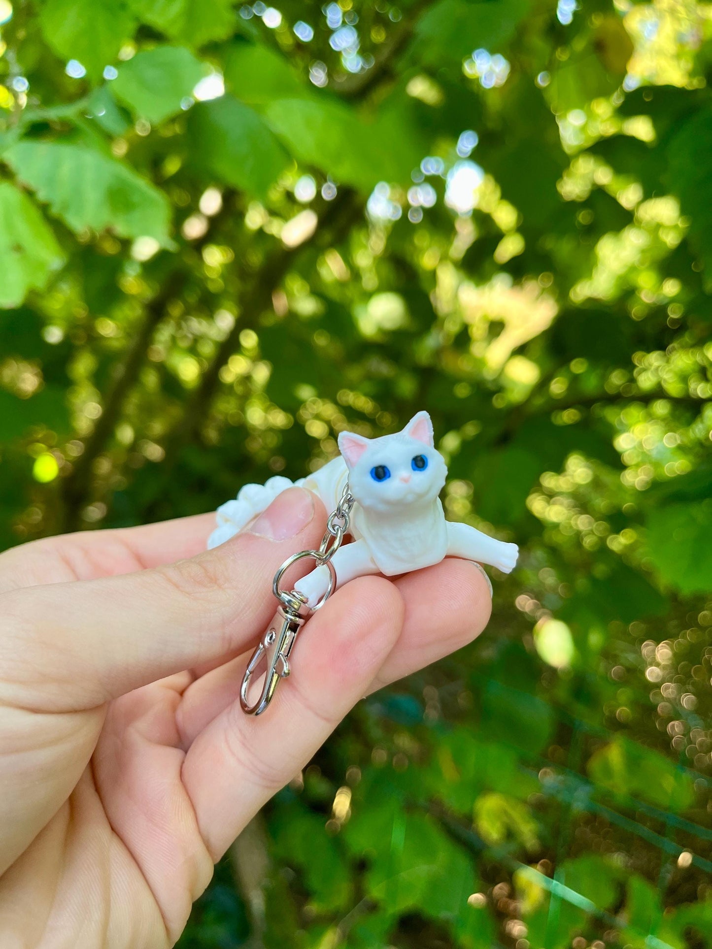 Articulated white cat keychain
